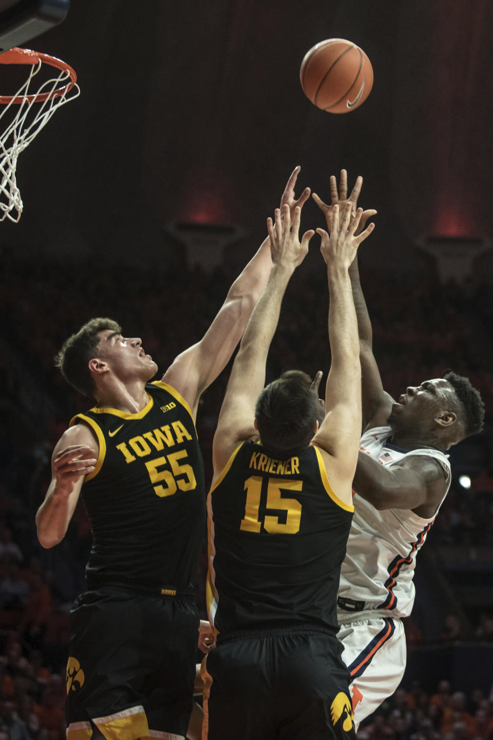 Illinois' Kofi Cockburn,right, shoots as Iowa's Luca Garza (55) and Ryan Kriener (15) defend in the first half of an NCAA college basketball game Sunday, March 8, 2020, in Champaign, Ill. (AP Photo/Holly Hart)