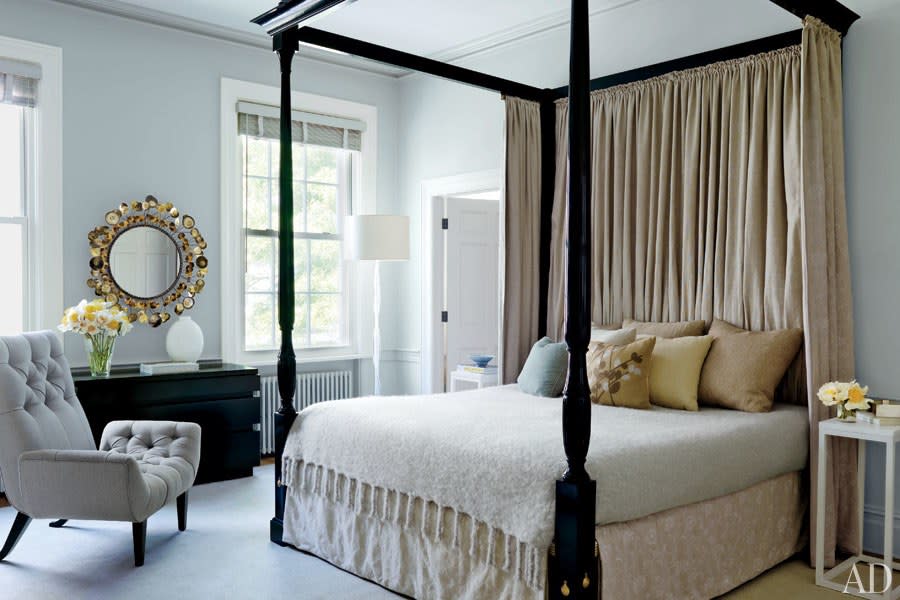 Painted in Benjamin Moore’s Gray Mist, the master bedroom of a <a rel="nofollow noopener" href="https://www.architecturaldigest.com/gallery/leroy-street-studio-christine-markatos-lowe-manhattan-townhouse-slideshow/all?mbid=synd_yahoo_rss" target="_blank" data-ylk="slk:Manhattan townhouse;elm:context_link;itc:0;sec:content-canvas" class="link ">Manhattan townhouse</a> designed by Leroy Street Studio architects and decorator Christine Markatos Lowe contains a Veere Grenney Assoc. four-poster and a 1940s Van Keppel–Green chest of drawers from Wyeth.