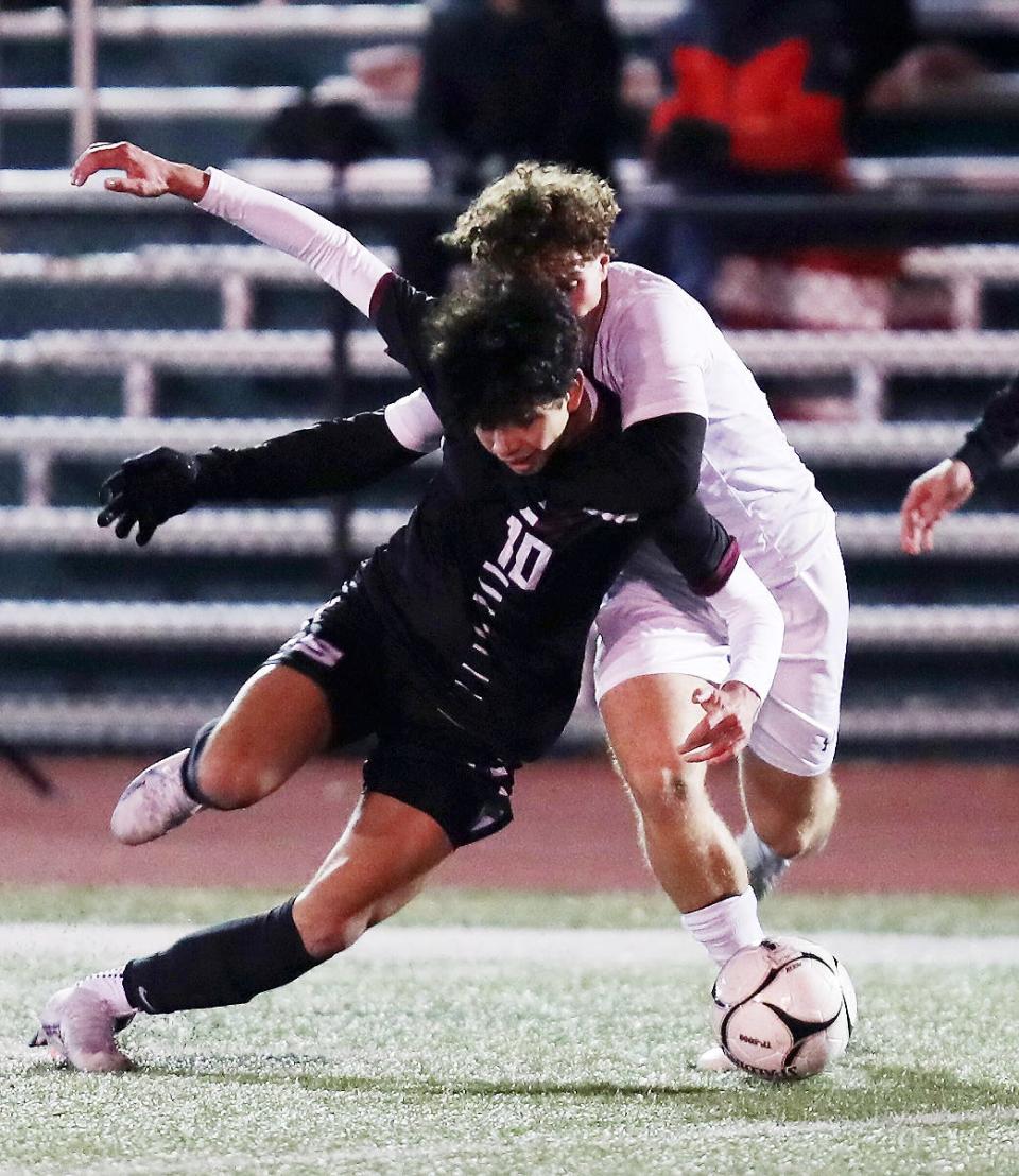 Scarsdale's Lorenzo Galeano (10) tries to get around Ithaca's Alexandros Lambrou (2) during boys soccer regional playoff at Yorktown High School Nov. 1, 2023. Scarsdale won the game 4-2.