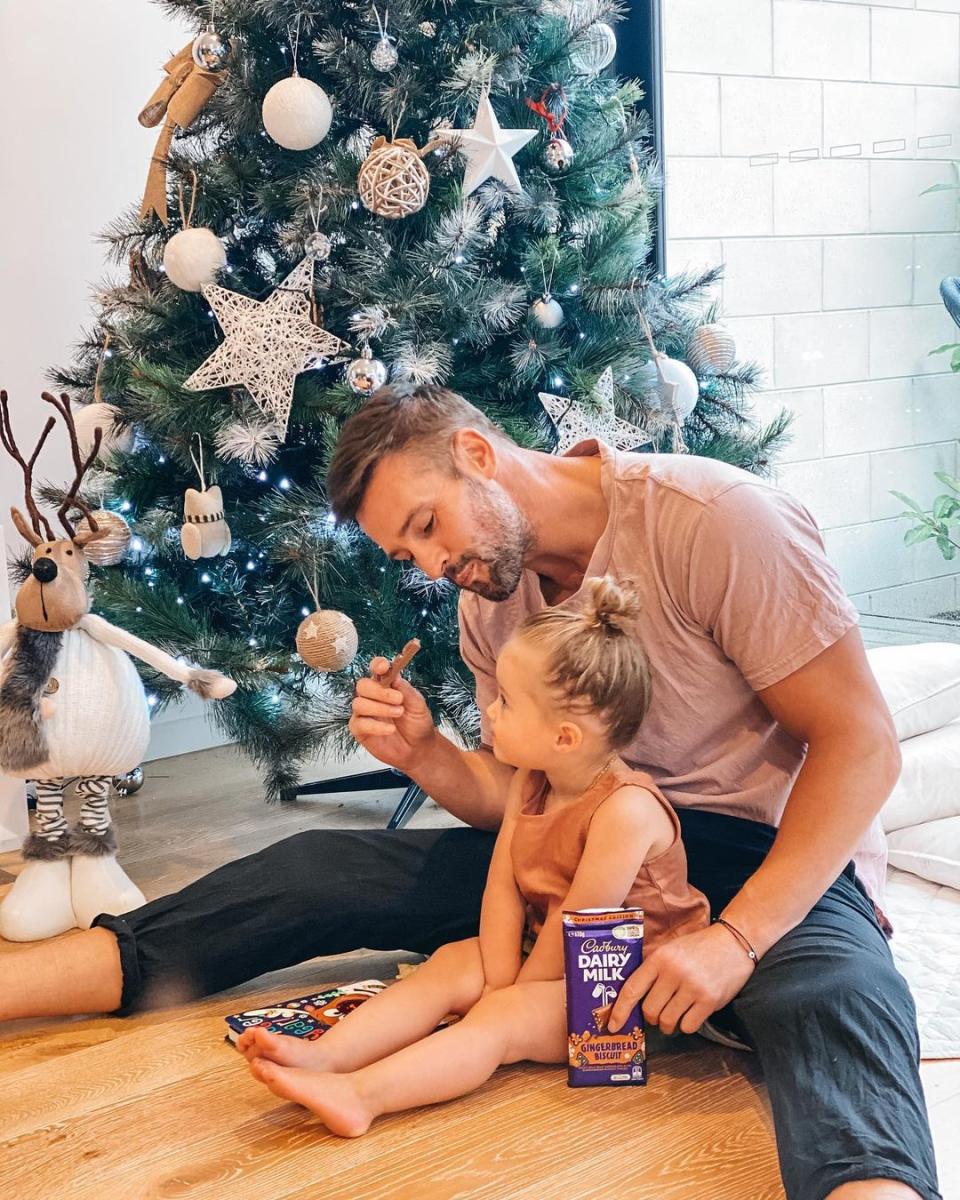 Kris Smith enjoyed a sweet treat in front of the tree with his almost-two-year-old daughter Mila. Photo: Instagram/krissmith13.