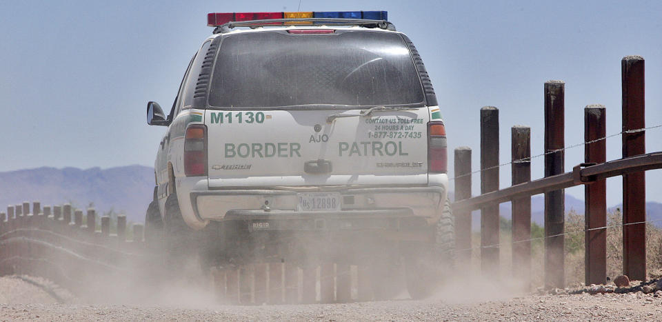 FILE - In this May 26, 2006 file photo, a U.S. Border Patrol agent patrols the international border separating Sonoyta, Mexico, right of fence, and Lukeville, Ariz., in Organ Pipe Cactus National Monument. Smugglers in recent weeks have been abandoning large groups of Guatemalan and other Central American migrants in the desert near Arizona's boundary with Mexico, alarming Border Patrol officials who say the trend is putting hundreds of children and adults at risk. (AP Photo/Matt York)