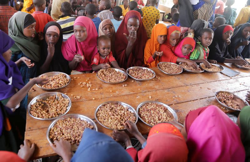 Internally displaced children eat a meal at the Kabasa Primary School in Dollow, Gedo Region