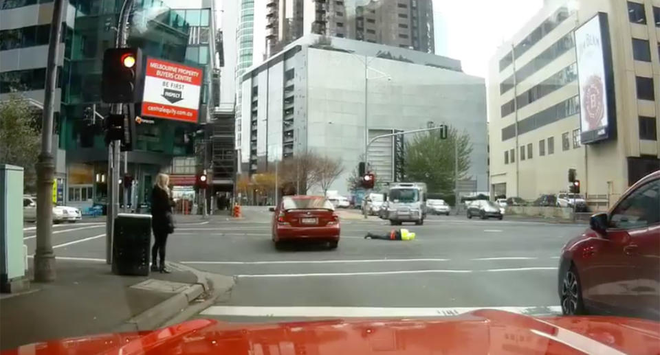 He lay facedown on the road as another pedestrian ran to help. Source: Facebook/Dash Cam Owners Australia