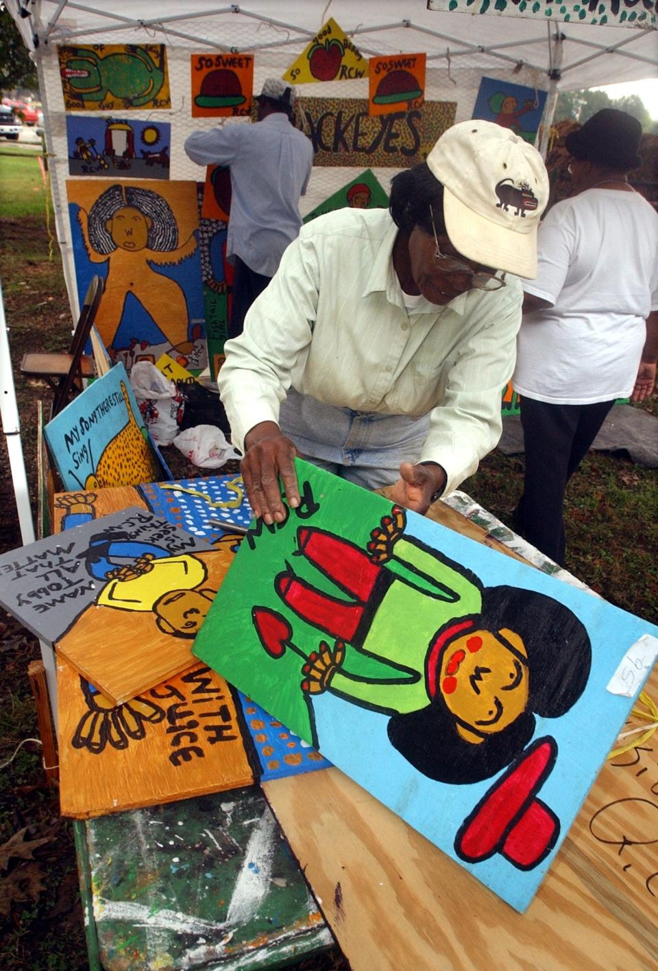 Artist Ruby C. Williams of Bealsville sorts through her paintings in her tent at the Kentuck Festival of the Arts in Northport, Alabama.