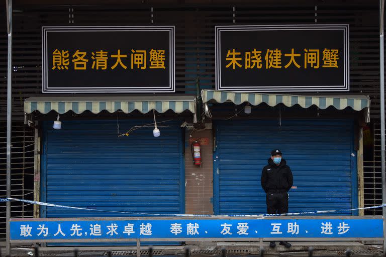 En esta foto de archivo tomada el 24 de enero de 2020, un guardia de seguridad frente al mercado de mariscos de Huanan, donde se detectó el coronavirus en Wuhan. 