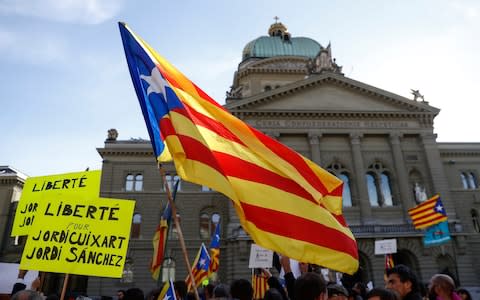 The Catalan flag is waved next to the Bundeshaus, the Swiss parliament building, during a demonstration in support of Catalonia, in Bern, Switzerland. - Credit: Peter Klaunzer/Keystone