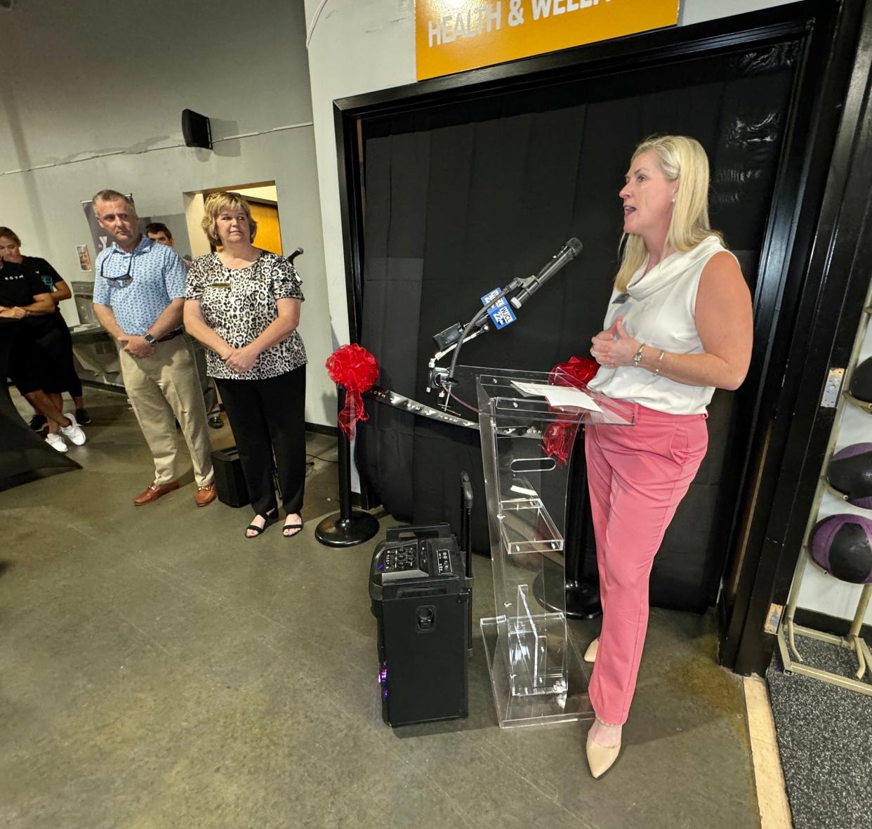 Summer Beal, president of the Richmond Hill Chamber of Commerce, speaks before a crowd during the ribbon cutting ceremony for the EGYM technology at the Richmond Hill YMCA.