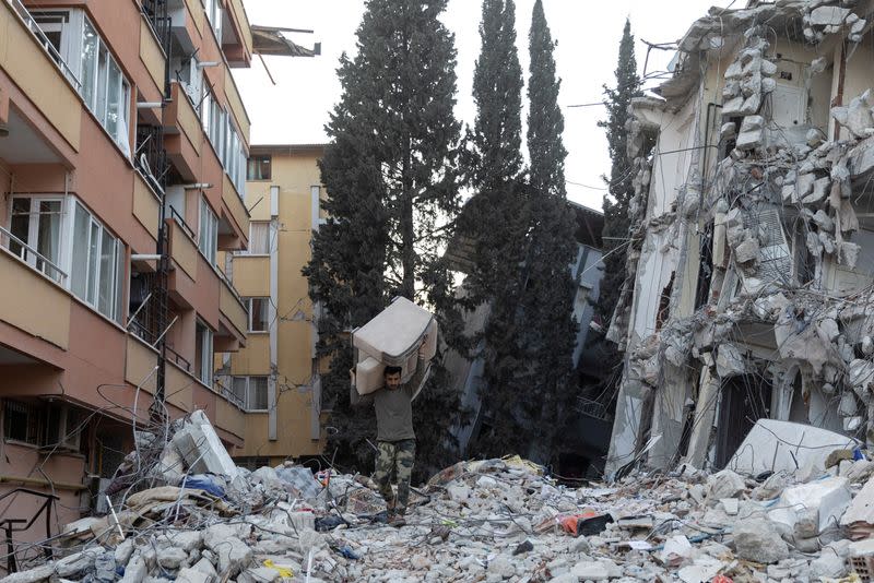 Un hombre saca un sofá de un edificio de apartamentos destruido tras el terremoto mortal en Antioquía