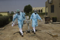 Doctors caring with COVID-19 patients ferry medical equipment, at the Farcha provincial hospital in N'Djamena, Chad, Friday April 30, 2021. While the world's wealthier nations have stockpiled coronavirus vaccines for their citizens, many poorer countries are scrambling to secure enough doses, and some, like Chad, have yet to receive any. (AP Photo/Sunday Alamba)