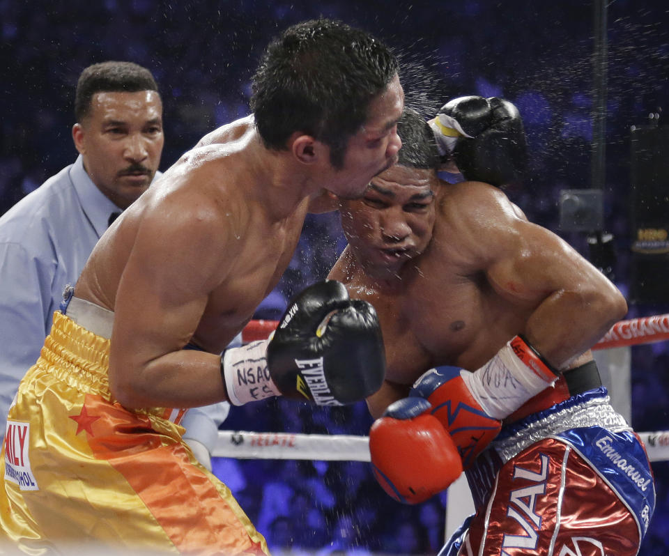 Yuriorkis Gamboa, from Miami, Fla., right, and Michael Farenas, from the Philippines, trade blows in close as referee Tony Weeks looks on during their WBA interim super featherweight title fight Saturday, Dec. 8, 2012, in Las Vegas. (AP Photo/Julie Jacobson)