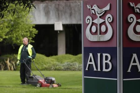 A gardener mows the grass outside the headquarters of AIB on the day the bank announced it's results, in Dublin April 12, 2011. REUTERS/Cathal McNaughton