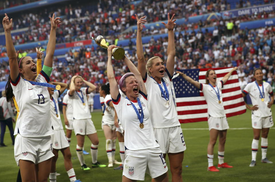 FILE- In this July 7, 2019, file photo, United States' Megan Rapinoe, center, holds the trophy as she celebrates with teammates after they defeated the Netherlands 2-0 in the Women's World Cup final soccer match at the Stade de Lyon in Decines, outside Lyon, France. (AP Photo/Francisco Seco, File)