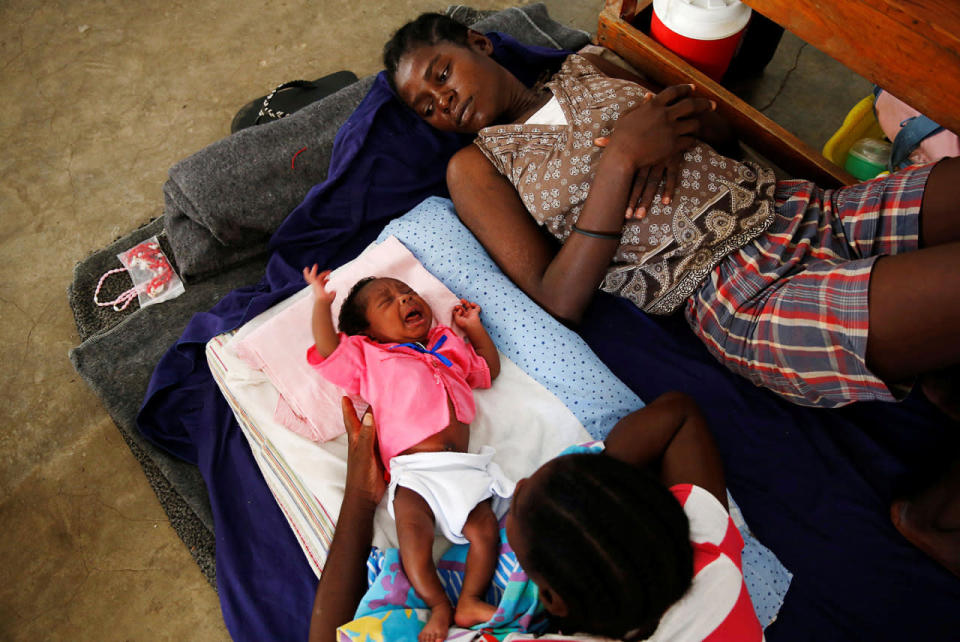 <p>Women and a child rest at a shelter set up at a school after Hurricane Matthew passes in Jeremie, Haiti, October 8, 2016. (REUTERS/Carlos Garcia Rawlins)</p>