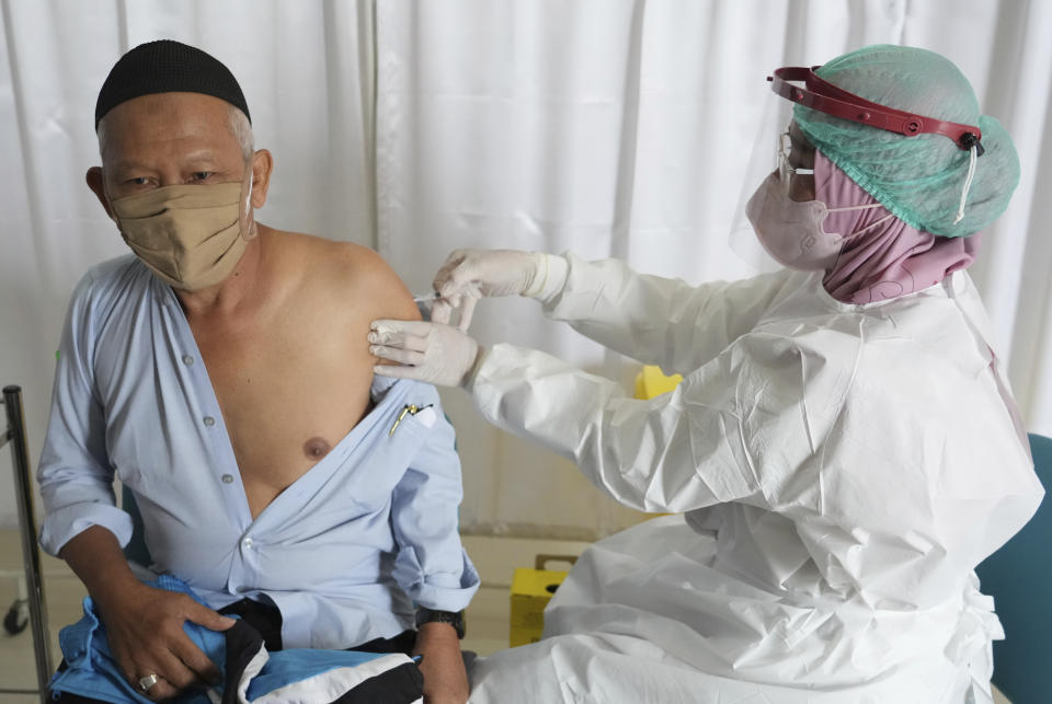 A man receives a booster shot of Pfizer COVID-19 vaccine during a third dose vaccination campaign at a South Tangerang Regional General Hospital in Tangerang, Indonesia, Wednesday, Jan. 12, 2022. Indonesia kicked off a COVID-19 booster campaign for the general public on Wednesday, prioritizing third shots for the elderly and people with compromised immune systems. (AP Photo/Tatan Syuflana)