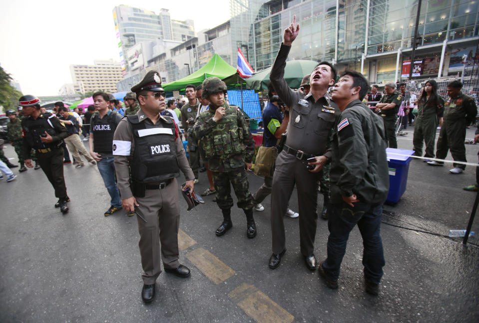 Police officers point to possible evidence at the scene of an explosion at a main protest site in Bangkok, Thailand, Sunday, Feb. 23, 2014. More than a dozen people were hurt Sunday by a small explosion at an anti-government protest in Bangkok, less than a day after a bloodier attack in an eastern province killed one child and left about three dozen people wounded. (AP Photo/Wally Santana)