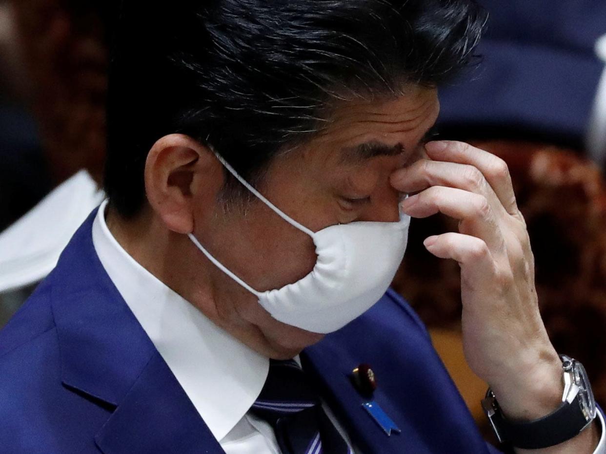 Japan's Prime Minister Shinzo Abe wears a protective face mask as he attends an upper house parliamentary session, following an outbreak of the coronavirus disease (COVID-19), in Tokyo, Japan April 1, 2020. REUTERS/Issei Kato