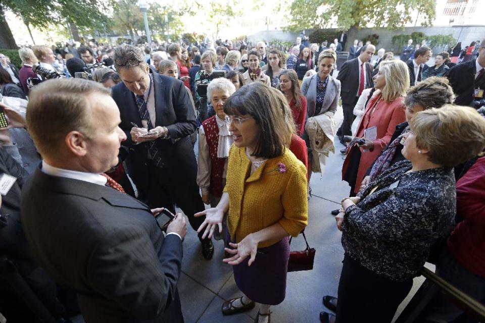 FILE - In this Oct. 5, 2013,file photo, Kate Kelly, center, with a group of about 200 feminist women are denied entrance to an all-male meeting of Mormon priesthood during the Mormon church conference, in Salt Lake City. More than 100,000 Latter-day Saints are expected in Salt Lake City this weekend for the church's biannual general conference. A Mormon's women group pushing the church to allow women in the priesthood plans to demonstrate outside an all-male meeting Saturday. The church has asked them to reconsider, and barred media from going on church property during the demonstration. (AP Photo/Rick Bowmer, File)