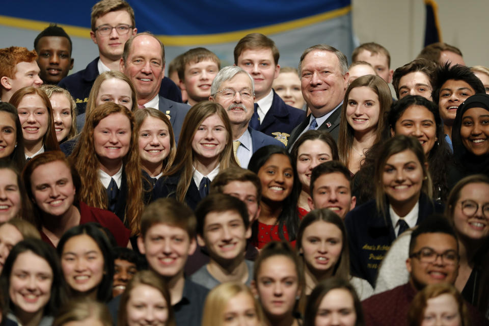 U.S. Ambassador to China Terry Branstad, center, and Secretary of State Mike Pompeo pose for a photo with Future Farmers of America and Johnston High School students, Monday, March 4, 2019, in Johnston, Iowa. (AP Photo/Charlie Neibergall)