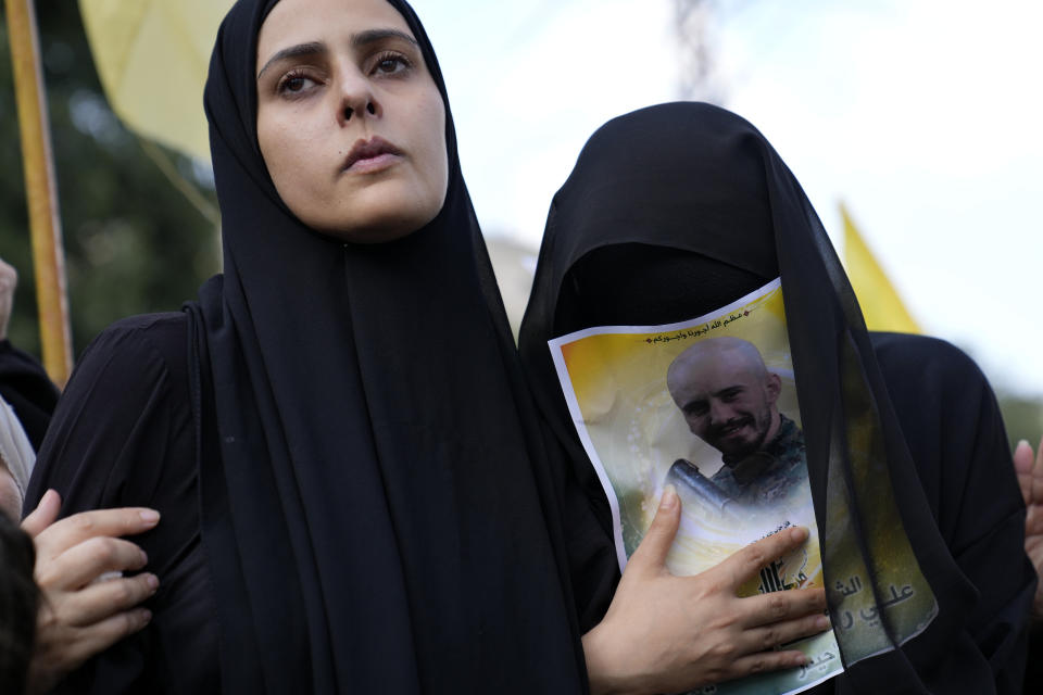 FILE - The wife, left, and sister of Hezbollah fighter Ali Ftouni, who was killed by Israeli shelling, mourn at his funeral procession in Kherbet Selem village, south Lebanon, Tuesday, Oct. 10, 2023. A war of words that has unfolded in Lebanon show longstanding schisms in the small country over Hezbollah, now amplified by the militant group's role in the Lebanon-Israel border clashes and by fears that an already crisis-hit Lebanon could be dragged into an all-out war.(AP Photo/Hussein Malla, File)