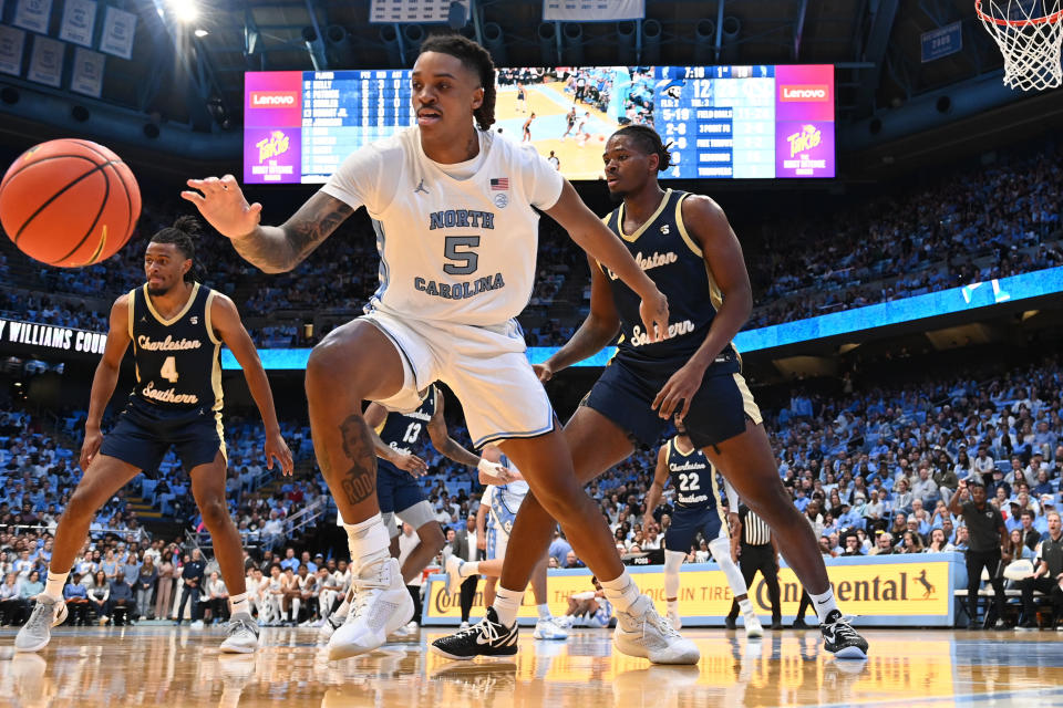 Dec 29, 2023; Chapel Hill, North Carolina, USA; North Carolina Tar Heels forward Armando Bacot (5) reaches for the ball as Charleston Southern Buccaneers guard DJ Patrick (4) and forward Taje’ Kelly (2) defend in the first half at Dean E. Smith Center. Bob Donnan-USA TODAY Sports