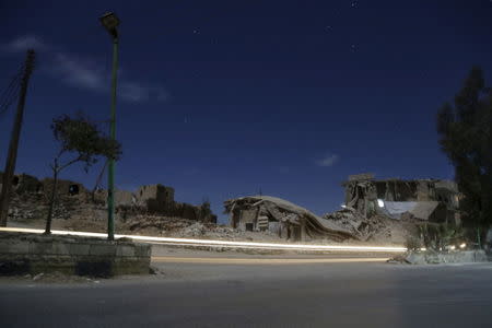 Damaged buildings are pictured at night in the rebel-controlled area of Maaret al-Numan town in Idlib province, Syria December 26, 2015. Picture taken with long exposure. REUTERS/Khalil Ashawi