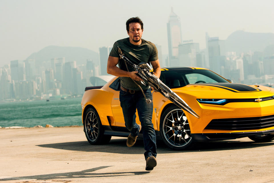 Mark Wahlberg runs from a car with a gun