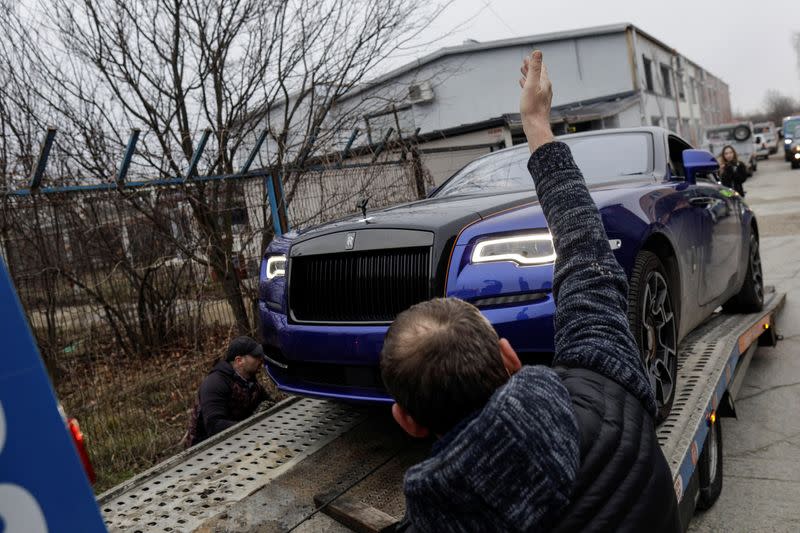 Romanian officials transport the cars seized from Andrew Tate's compound to a storage location