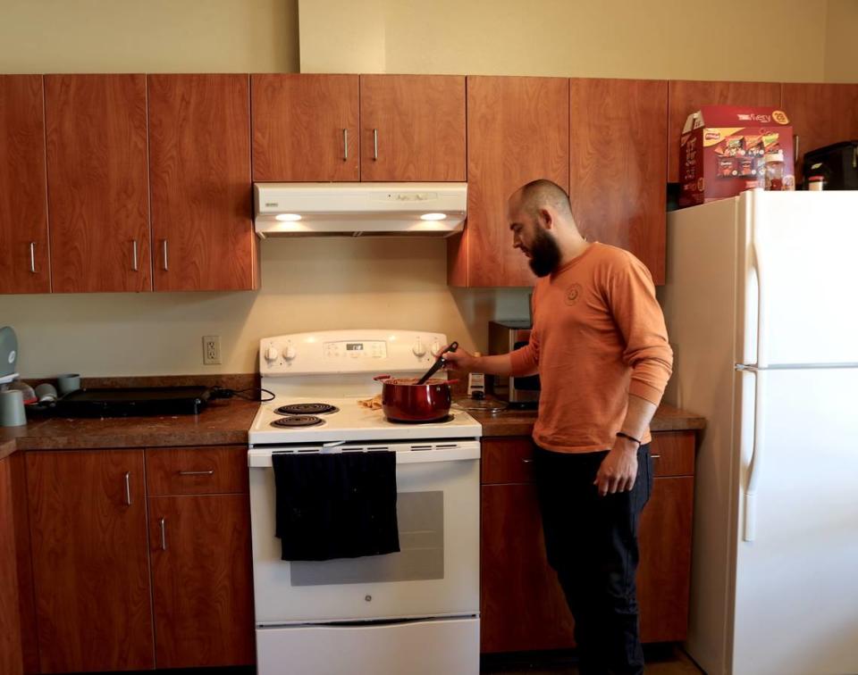 Marcos Gonzalez Rios, an H-2A worker from Mexico, cooks a meal in the kitchen of his housing unit at Ringold in Mesa, WA.