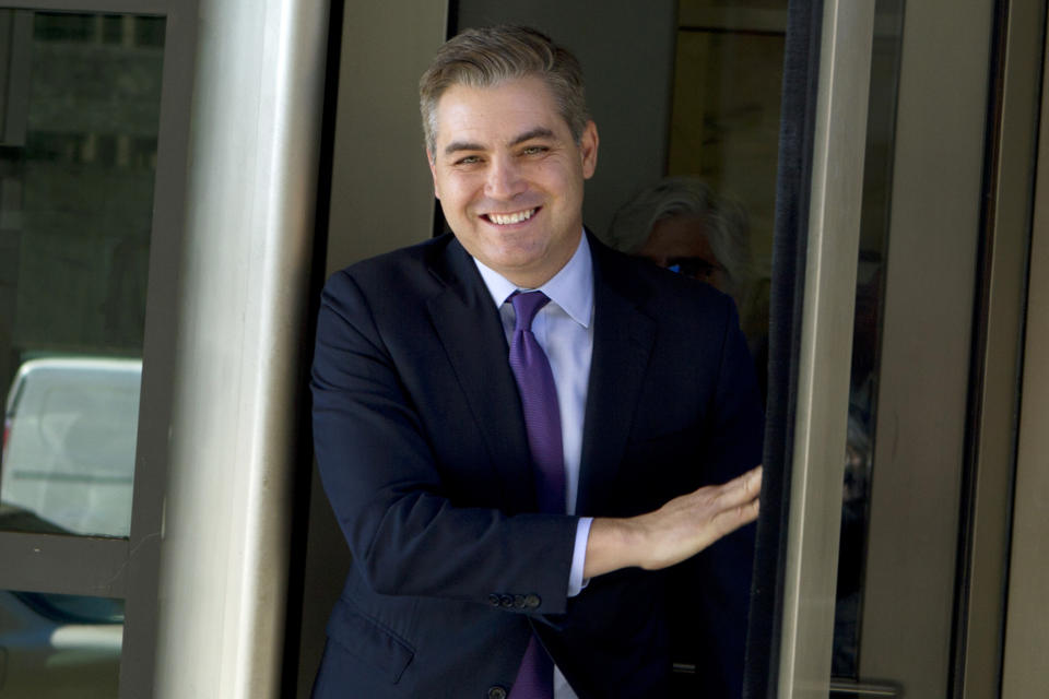 CNN’s Jim Acosta walks out of the U.S. District Courthouse with a smile, after the Friday hearing. (AP Photo/Jose Luis Magana)