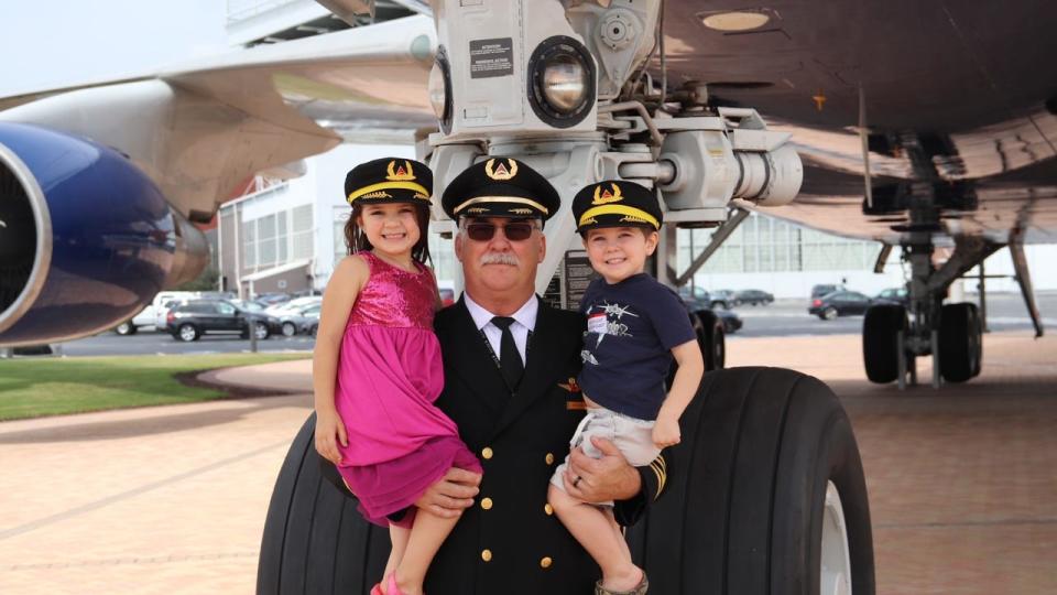 <div>Retired Delta Airlines pilot Captain Jeff Vickers poses with two of his grandchildren.</div>