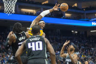 Sacramento Kings center Richaun Holmes, left, and forward Harrison Barnes (40) guard against Golden State Warriors center Kevon Looney, top left, during the first quarter of an NBA basketball game in Sacramento, Calif., Sunday, Oct. 24, 2021. (AP Photo/Randall Benton)