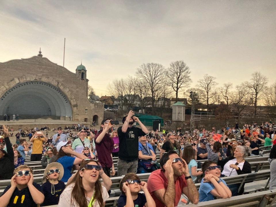 People watch the solar eclipse from the Toledo Zoo in Toledo on Monday, April 8, 2024.