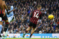 Manchester City's Jeremy Doku, left, scores his side's third goal during the English Premier League soccer match between Manchester City and Bournemouth at the Etihad stadium in Manchester, England, Saturday, Nov. 4, 2023. (AP Photo/Dave Thompson)
