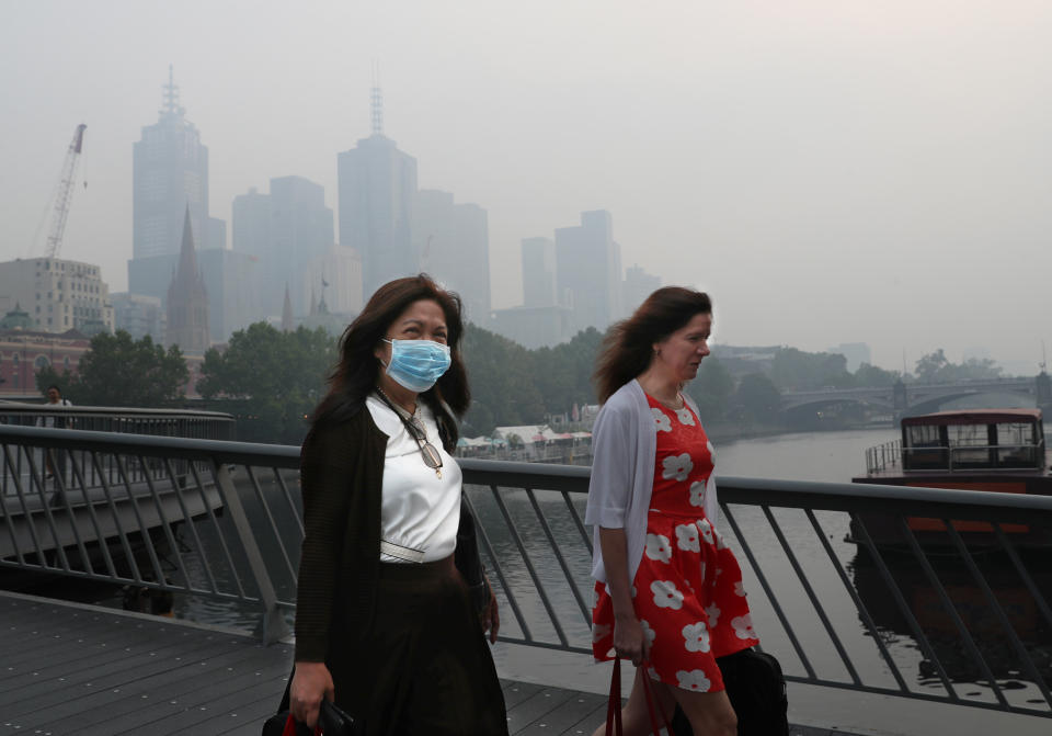 People wear breathing masks to protect themselves from a thick smoke haze that hangs over Melbourne from the bushfires. Source: AAP