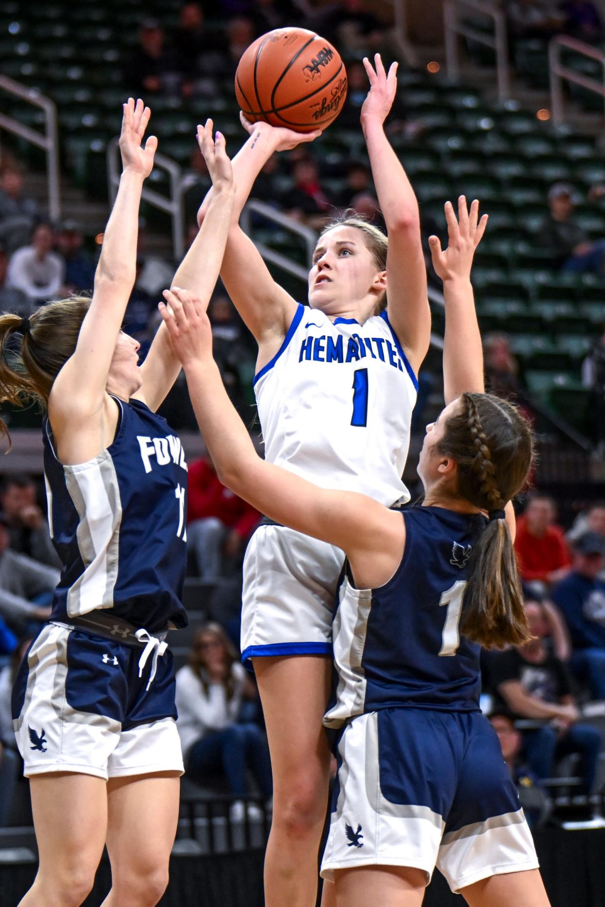 Ishpeming's Jenna Maki, center, scores between Fowler's Kelcie Pung, left, and Selena Stump during the second quarter in the Division 4 girls basketball state semifinal on Thursday, March 21, 2024, at the Breslin Center in East Lansing.