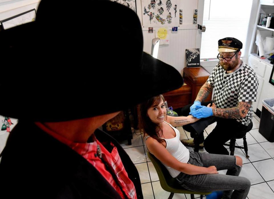 Wes Grimm, left, stops to chat with Davey Gant and Allison Crain, who was back in Kansas City recently to visit friends and family. Gant works out of a space at the Bert Grimm Tattoo Museum, 311 W. 39th St., just around the corner from Grimm Tattoo shop.