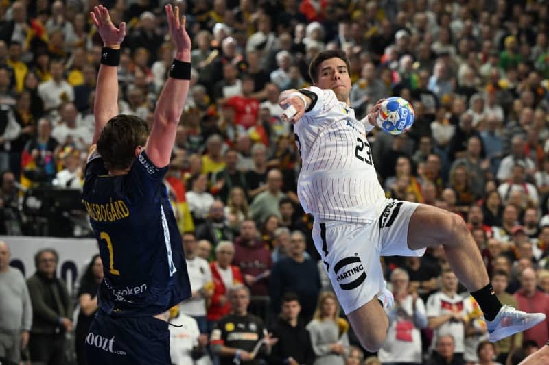 Germany's Renars Uscins (R) in action against Sweden's Jonathan Carlsbogard during the 2024 EHF European Men's 3rd place Handball match between Sweden and Germany at Lanxess Arena. Federico Gambarini/dpa