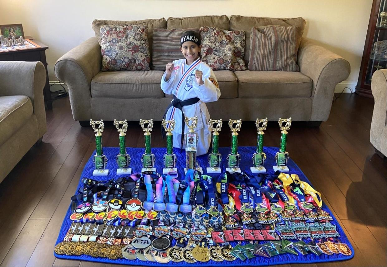 Twinsburg's Liyara Mananayaka poses with her 99 medals as she prepares for a busy summer season in taekwondo.