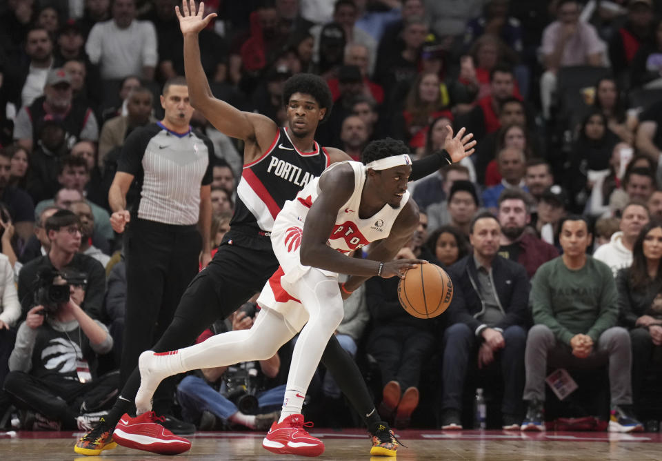 Toronto Raptors forward Pascal Siakam, right, loses a shoe as he moves past Portland Trail Blazers guard Scoot Henderson (00) during second-half NBA basketball game action in Toronto, Monday, Oct. 30, 2023. (Nathan Denette/The Canadian Press via AP)