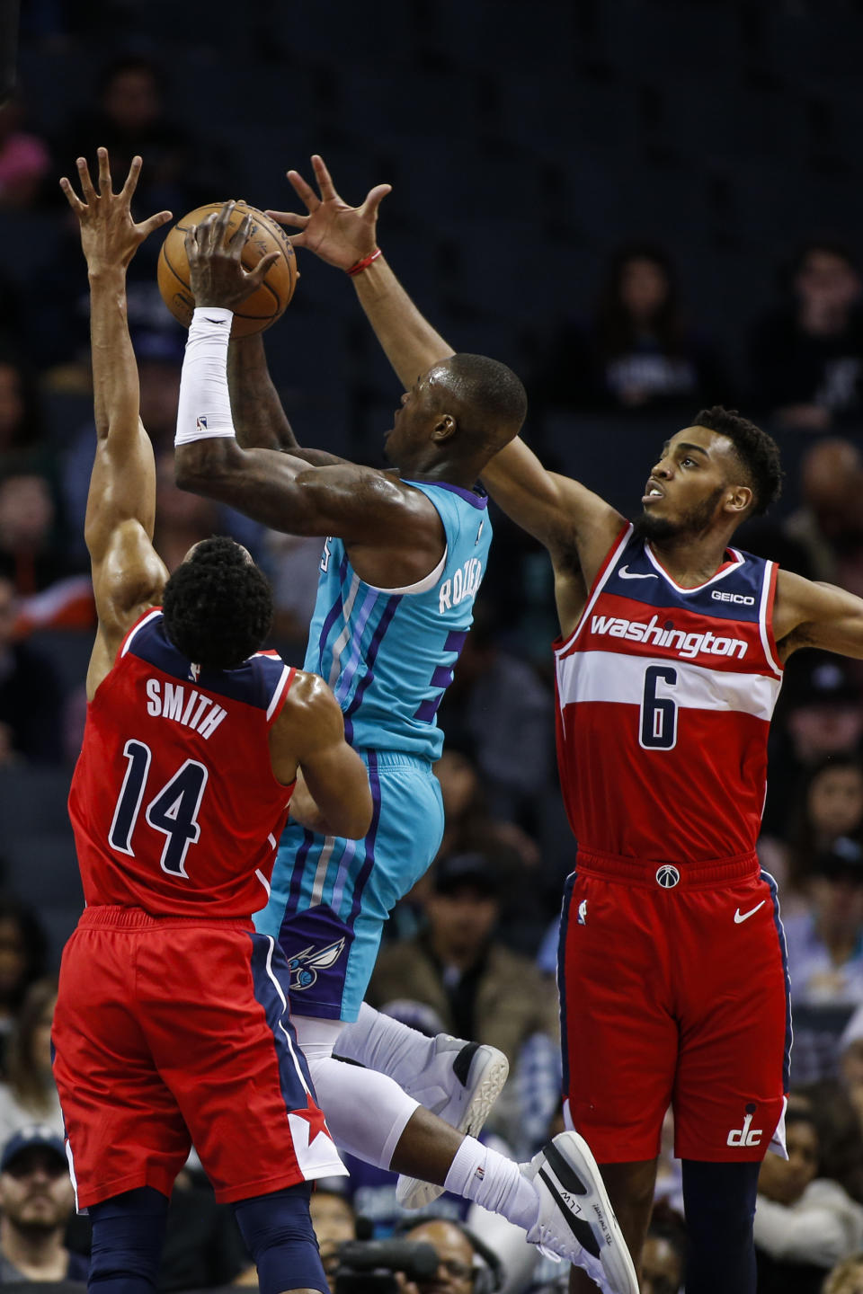 Charlotte Hornets guard Terry Rozier, center, shoots between Washington Wizards guards Ish Smith (14) and Troy Brown Jr. (6) in the first half of an NBA basketball game in Charlotte, N.C., Tuesday, Dec. 10, 2019. (AP Photo/Nell Redmond)