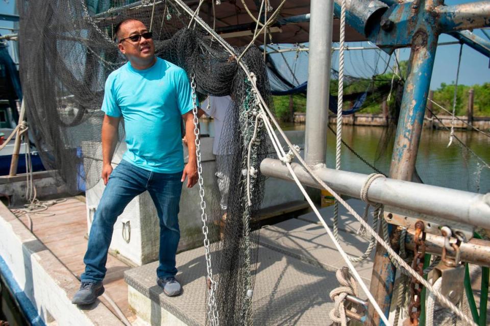 Elvis Ta stands on his father’s shrimping boat, Miss Mimi, at Bayou Caddy in Bay St. Louis on Thursday, June 29, 2023. Instead of following his father into the shrimping industry, Ta works for the Department of Agriculture, owns an HVAC company and DJs for weddings on the side.