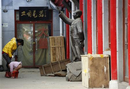 A girl urinates near a statue of China's late Chairman Mao Zedong at an antique market in Beijing, November 25, 2013. REUTERS/Kim Kyung-Hoon