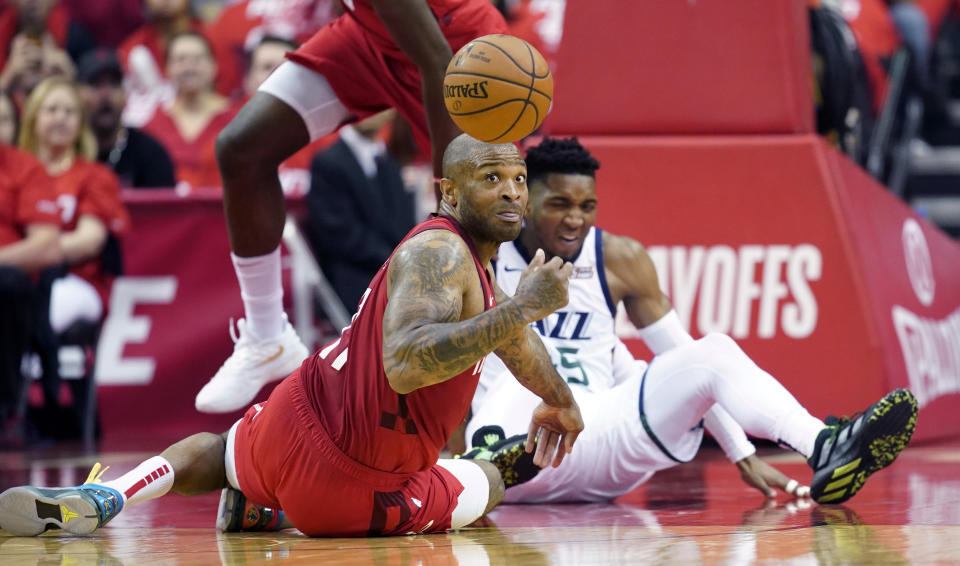 Houston Rockets forward PJ Tucker, left, and Utah Jazz guard Donovan Mitchell, right, scramble for a loose ball during the first half in Game 5 of an NBA basketball playoff series, in Houston, Wednesday, April 24, 2019. (AP Photo/David J. Phillip)