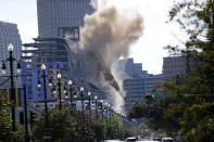 Two large cranes from the Hard Rock Hotel construction collapse come crashing down after being detonated for implosion in New Orleans, Sunday, Oct. 20, 2019. New Orleans officials set off several explosions Sunday intended to topple two cranes that had been looming over the ruins of a partially collapsed Hard Rock Hotel. (AP Photo/Gerald Herbert)