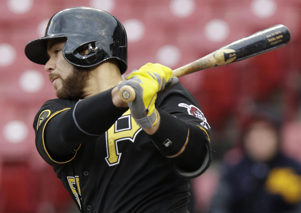 Pittsburgh Pirates' Russell Martin follows through on a hit off Cincinnati Reds relief pitcher Sam LeCure on Tuesday, April 15, 2014, in the seventh inning of a baseball game that was suspended by rain Monday in Cincinnati. (AP Photo/Al Behrman)