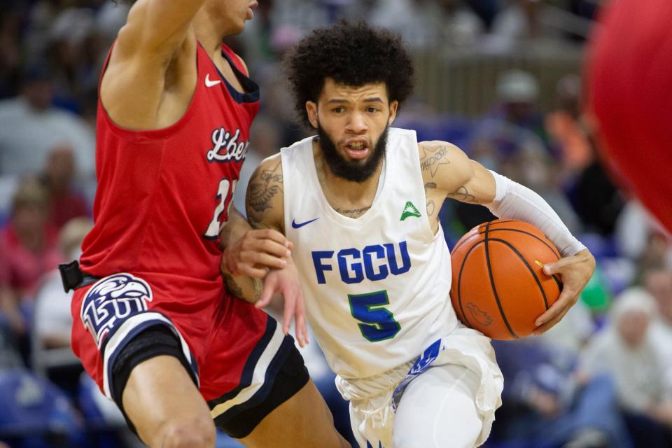 Florida Gulf Coast Eagles guard Tavian Dunn-Martin (5) drives against Liberty Flames guard Joseph Venzant (23) during the ASUN men’s basketball game between FGCU and Liberty, Saturday, Jan. 15, 2022, at Alico Arena in Fort Myers, Fla.Liberty defeated FGCU 78-75.