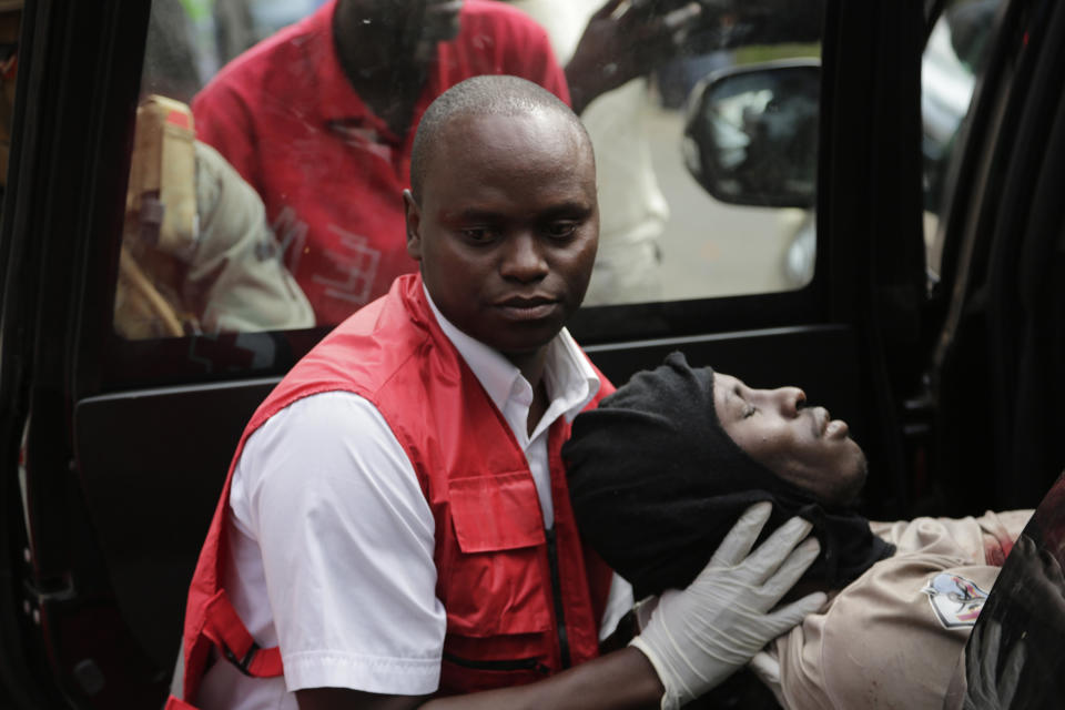 A wounded member of Kenyan special forces is carried from a US embassy diplomatic vehicle into an ambulance by red cross paramedics at the scene Wednesday, Jan. 16, 2019 in Nairobi, Kenya. Extremists stormed a luxury hotel in Kenya's capital on Tuesday, setting off thunderous explosions and gunning down people at cafe tables in an attack claimed by Africa's deadliest Islamic militant group (AP Photo/Khalil Senosi)