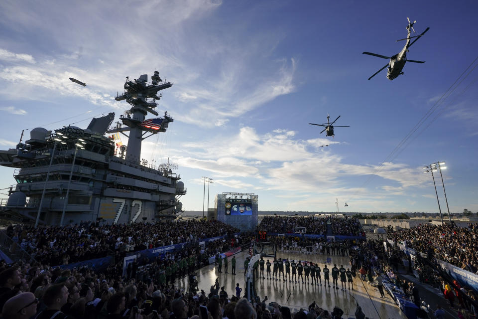 Players for Michigan State and Gonzaga stand during the singing of the national anthem and a flyover before the Carrier Classic NCAA college basketball game aboard the USS Abraham Lincoln, Friday, Nov. 11, 2022, in Coronado, Calif. (AP Photo/Gregory Bull)