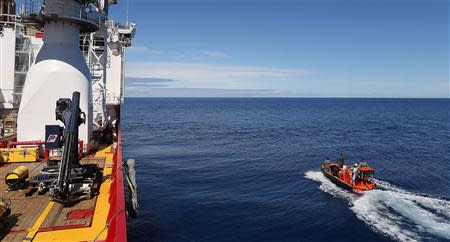 Crew members are seen aboard a fast response craft (R) from the Australian Defence Vessel Ocean Shield (L) as they continue to search for debris of the missing Malaysian Airlines flight MH370 in the southern Indian Ocean, in this picture released by the Australian Defence Force on April 8, 2014. REUTERS/Australian Defence Force/Handout via Reuters