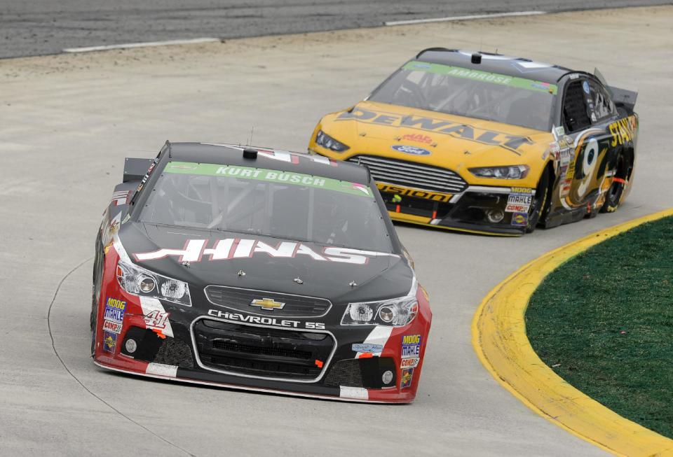 Driver Kurt Busch (41) drives through turn four as Marcos Ambrose (9) follows during a NASCAR Sprint Cup auto race at Martinsville, Speedway in Martinsville, VA., Sunday March 30, 2014. (AP Photo/Mike McCarn)